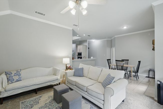 Living area with crown molding, recessed lighting, ceiling fan, and visible vents | Image 21