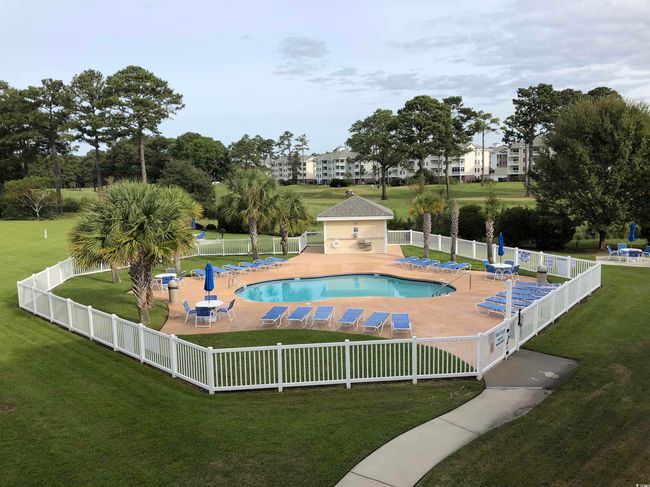 Community pool with a patio area, fence, and a lawn | Image 27