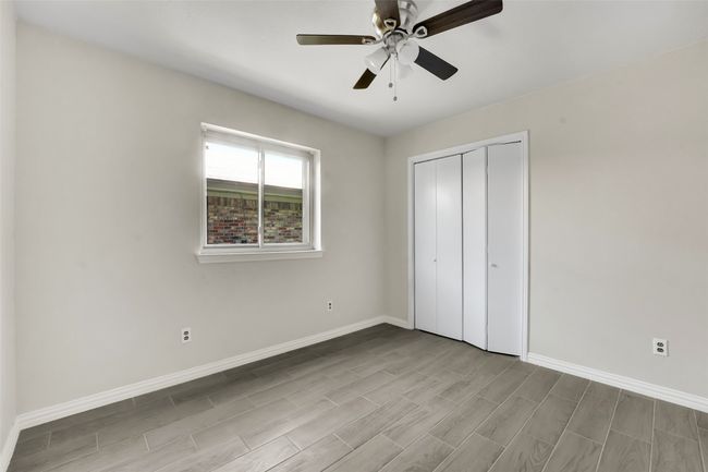 Unfurnished bedroom featuring wood finished floors, a closet, and ceiling fan | Image 8