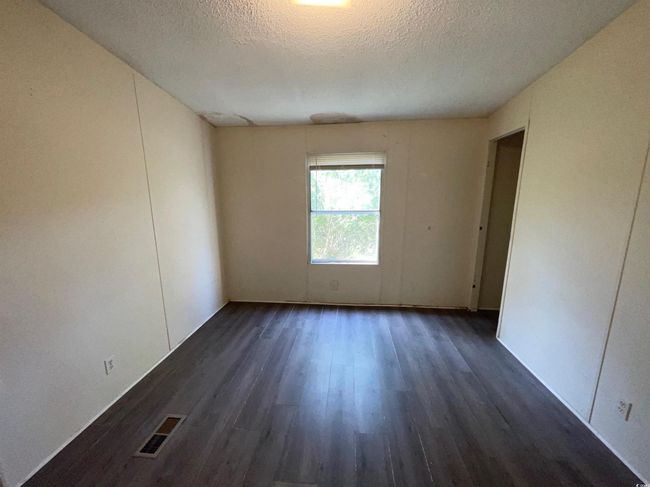 Unfurnished room featuring visible vents, a textured ceiling, and dark wood finished floors | Image 13
