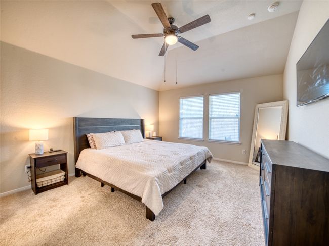 Carpeted bedroom featuring ceiling fan and lofted ceiling | Image 10