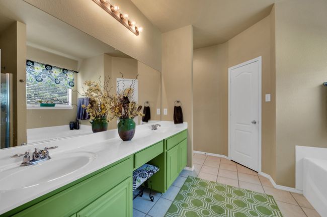 Full bathroom with double vanity, tile patterned flooring, and a bath | Image 21