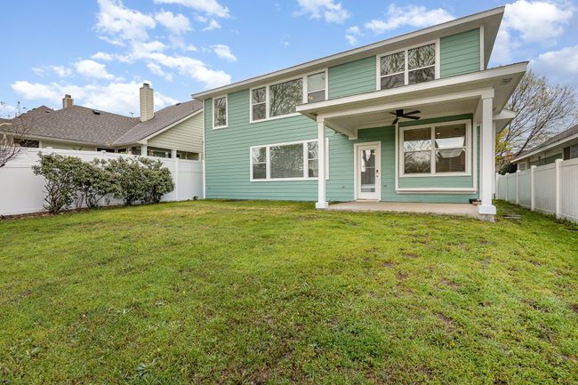 Back of property with a fenced backyard, a lawn, a patio area, and ceiling fan | Image 27