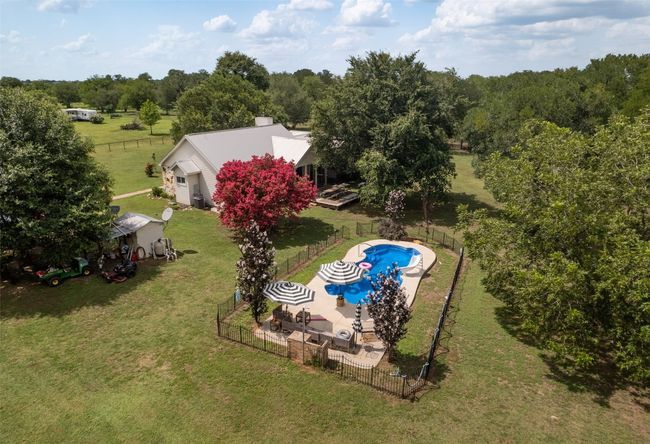 View of swimming pool featuring a fenced backyard and a patio area | Image 27