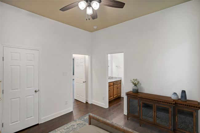 Bedroom with dark wood-style flooring, ensuite bath, and a ceiling fan | Image 19