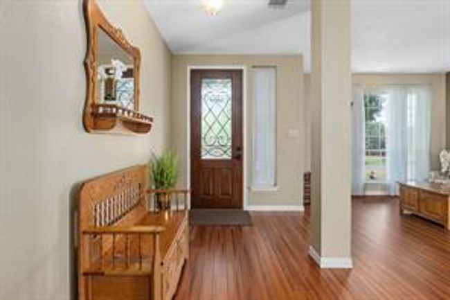 Entryway featuring vaulted ceiling, plenty of natural light, wood finished floors, and baseboards | Image 16