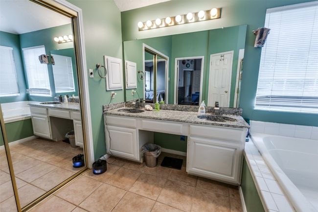 Full bath featuring double vanity, tile patterned flooring, a garden tub, and a wealth of natural light | Image 25