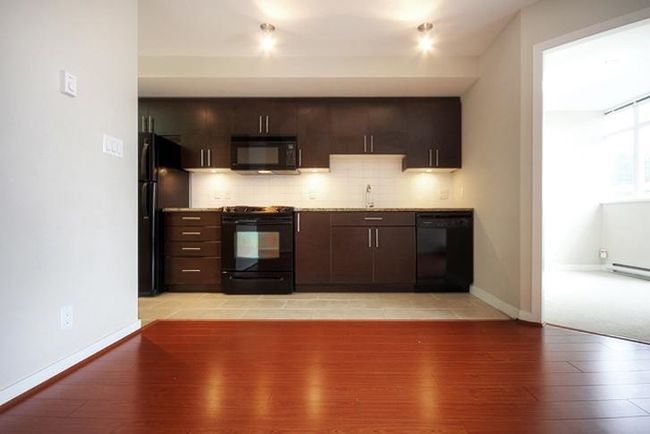 Bar featuring a sink, black appliances, light wood finished floors, backsplash, and baseboards | Image 8