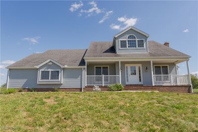 View of front of home with a porch and a front yard | Image 1