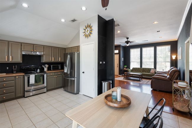 Kitchen featuring appliances with stainless steel finishes, under cabinet range hood, gray cabinetry, ceiling fan, and light tile patterned floors | Image 6