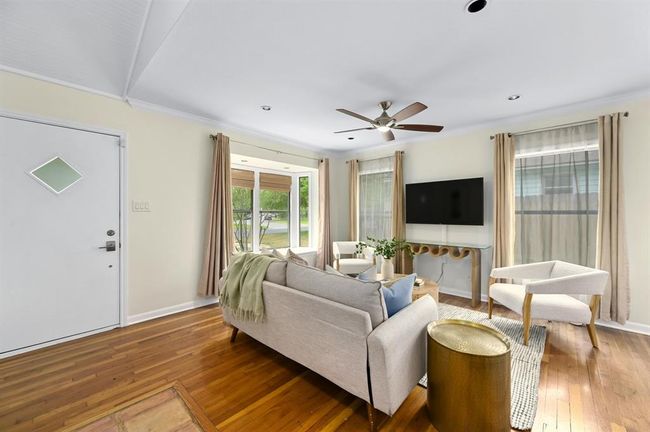 Living room featuring wood-type flooring, crown molding, and a ceiling fan | Image 4