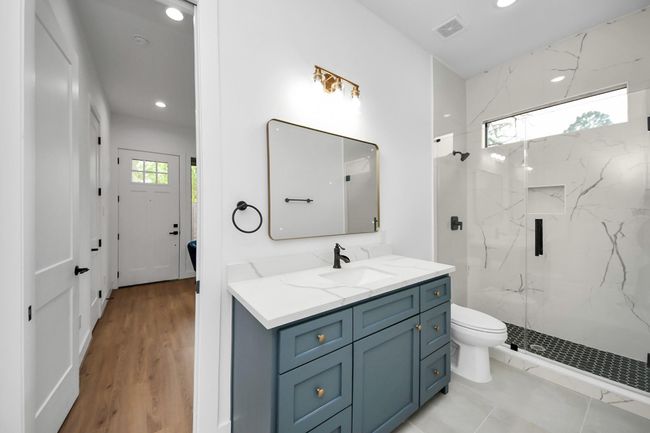 Secondary bathroom features a walk-in shower with tile surround and spacious vanity. | Image 25