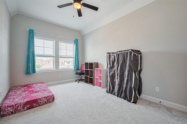 This well-appointed secondary bedroom features plush carpeting, a large window for natural light | Image 26