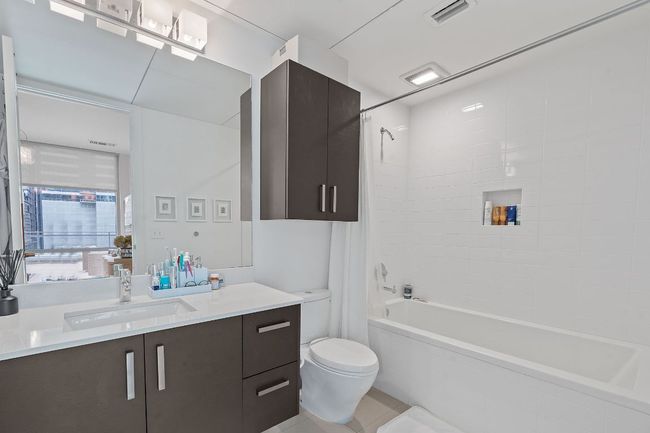 Bathroom with vanity, toilet, shower / tub combo, and tile patterned flooring | Image 17