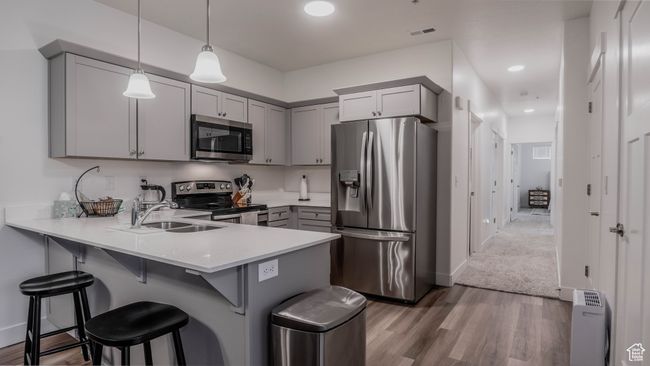 Kitchen featuring a peninsula, gray cabinetry, visible vents, and appliances with stainless steel finishes | Image 11