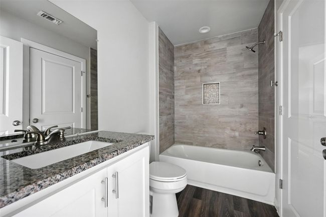 Full bathroom with shower / bathtub combination, vanity, and dark wood-style floors | Image 13