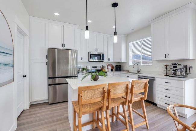 Kitchen featuring a sink, white cabinetry, and stainless steel appliances | Image 7