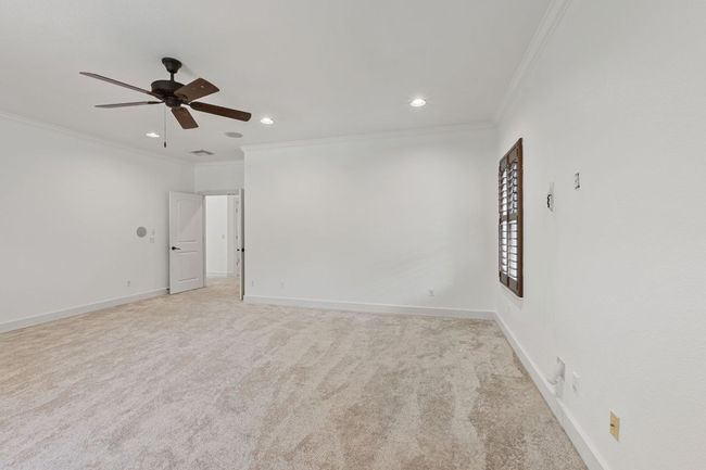 Empty room featuring ornamental molding, recessed lighting, a ceiling fan, and light colored carpet | Image 19