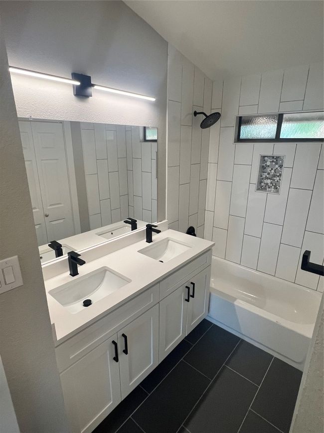 Full bathroom featuring double vanity, bathing tub / shower combination, and tile patterned floors | Image 12