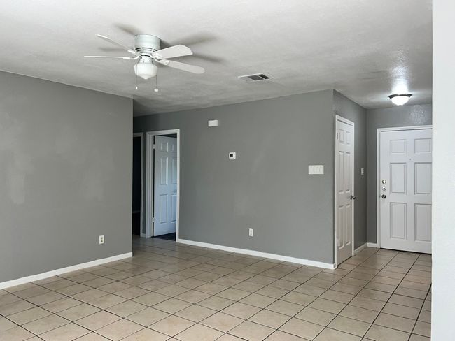 Empty room featuring light tile patterned flooring and ceiling fan | Image 5