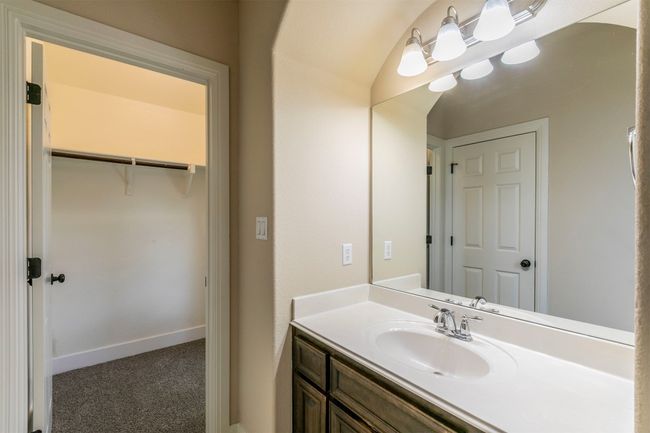 Bathroom 2 with a walk in closet, baseboards, and vanity | Image 27