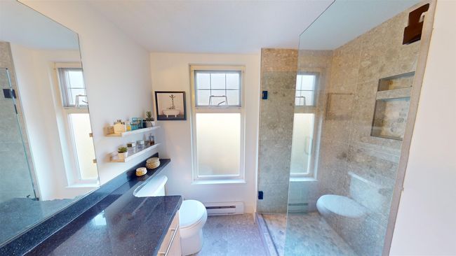 Full bathroom with a tile shower, plenty of natural light, toilet, and baseboard heating | Image 13