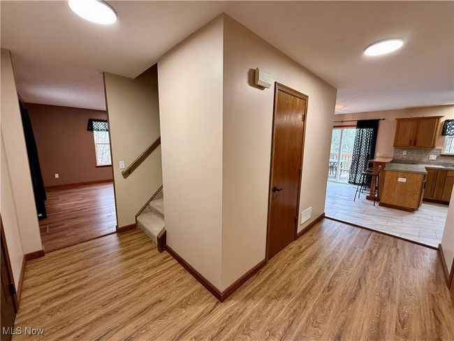 Hall featuring light wood-type flooring, baseboards, and stairway | Image 6