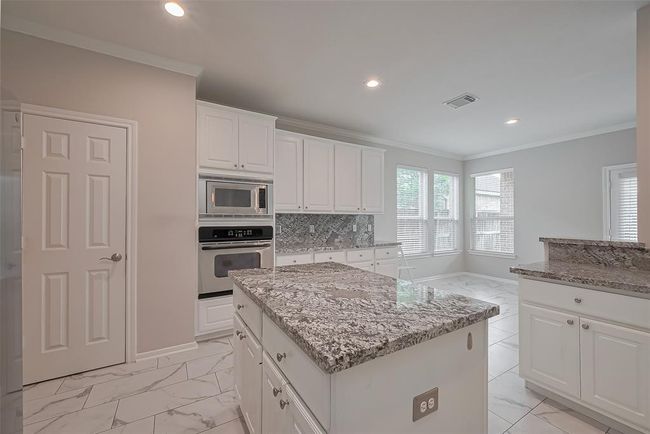 The kitchen with ample cabinetry and pantry. | Image 10
