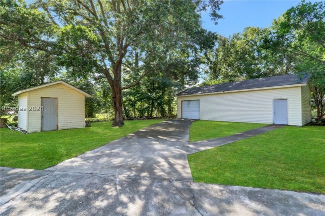 View of front facade featuring a garage, an outbuilding, and a front lawn | Image 32