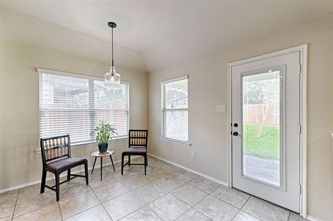 Sitting room with light tile patterned floors and lofted ceiling | Image 11