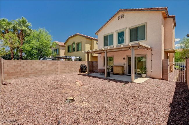 Rear view of house featuring stucco siding, a patio, a fenced backyard, and a tile roof | Image 30