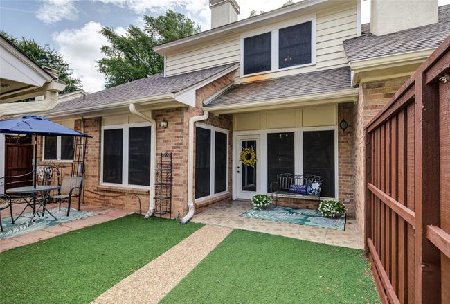 Rear view of property with a shingled roof, a patio, a chimney, brick siding, and a yard | Image 26