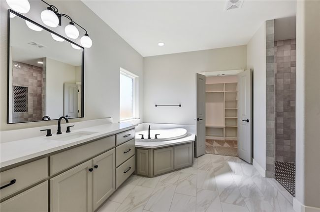 Bathroom with tiled shower, vanity, a bath, a spacious closet, and marble finish flooring | Image 19