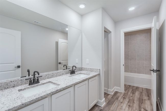 Bathroom with double vanity, wood finished floors, visible vents, and a sink | Image 13