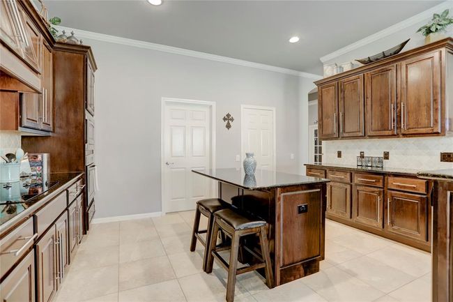 The kitchen is well-lit and includes modern appliances, with a neutral palette offering a clean and inviting atmosphere. | Image 16