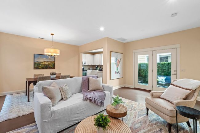 The living room is open to the dining room with updated lighting. | Image 14