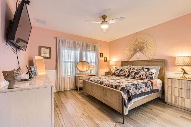Bedroom with light wood-style flooring, ceiling fan, and wainscoting | Image 14
