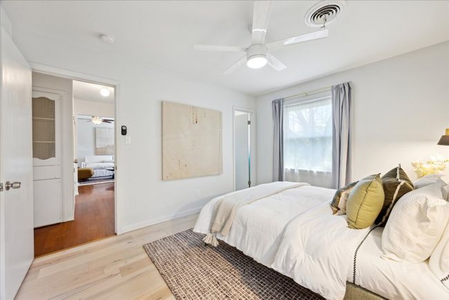 Bedroom featuring light wood-type flooring, visible vents, baseboards, and a ceiling fan | Image 15