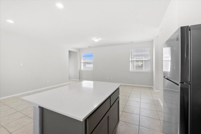 Kitchen featuring light tile patterned floors, light countertops, and freestanding refrigerator | Image 10