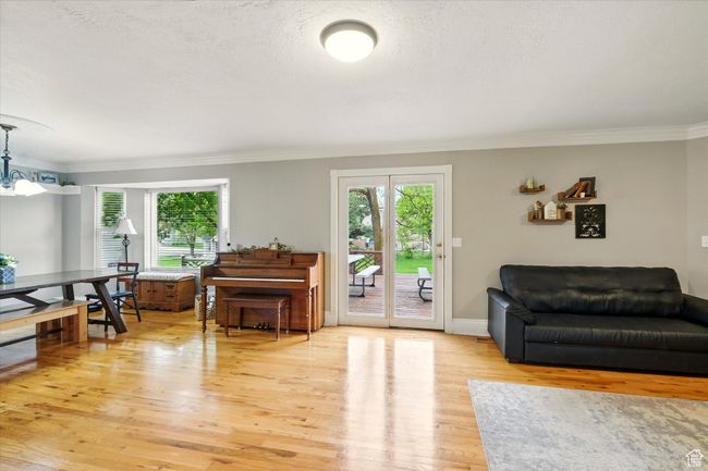 Living area featuring healthy amount of natural light, light wood-type flooring, and crown molding | Image 29