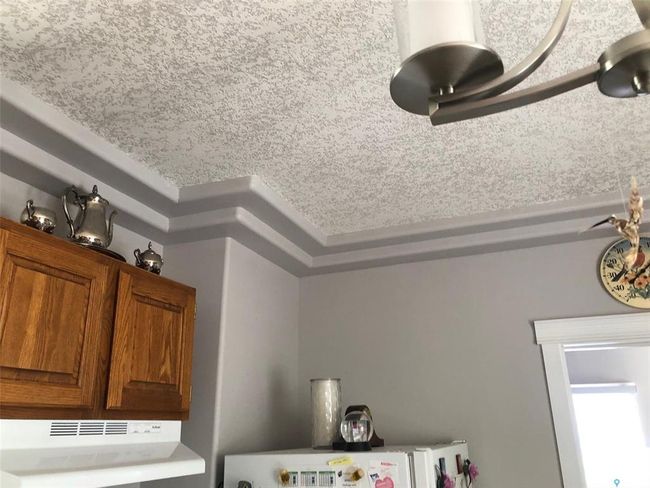 Kitchen view of under cabinet range hood and brown cabinetry | Image 21