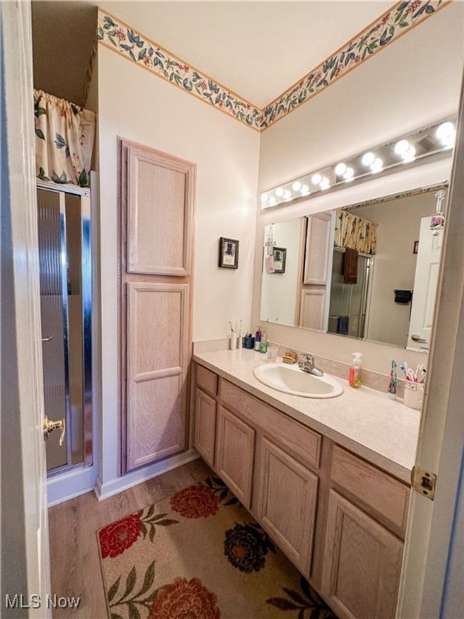 Bathroom featuring vanity, curtained shower, and hardwood / wood-style flooring | Image 11