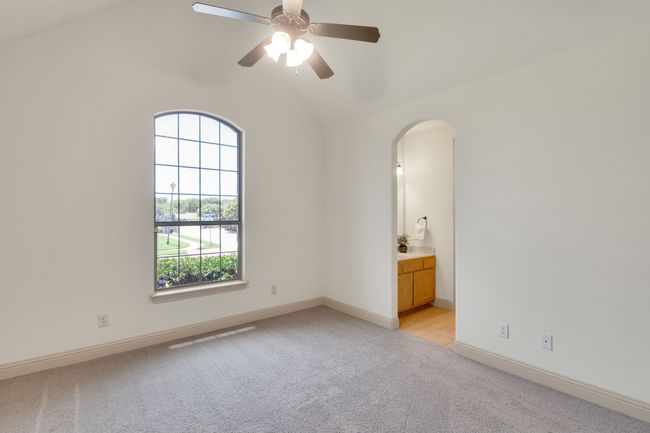 Unfurnished room with light carpet, arched walkways, vaulted ceiling, and ceiling fan | Image 28