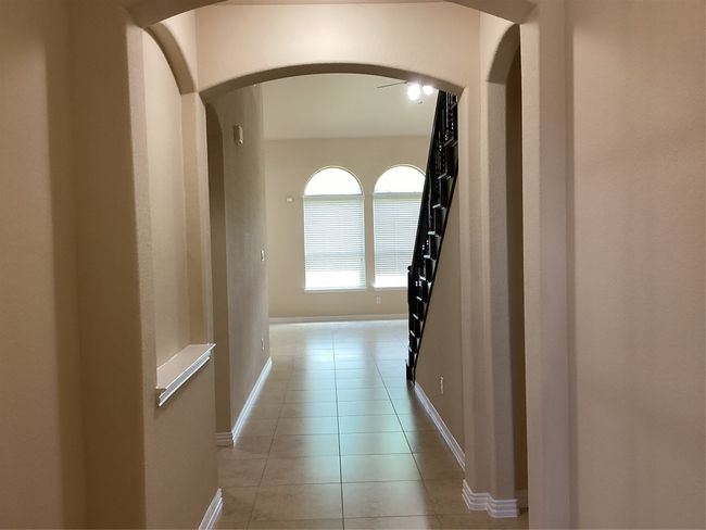 Hall with arched walkways, light tile patterned floors, and baseboards | Image 21