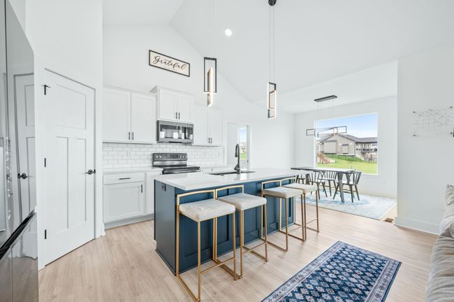 Kitchen featuring stainless steel microwave, electric stove, a sink, light wood finished floors, and white cabinets | Image 10