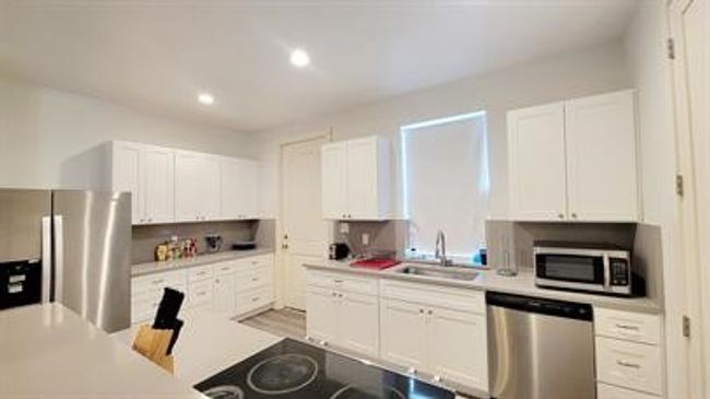 Kitchen with stainless steel appliances, light countertops, white cabinets, and recessed lighting | Image 8