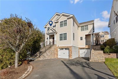 View of front of property with a garage. House is the left side. | Image 1