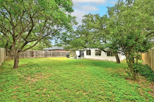 Rear view of house featuring a patio, a fenced backyard, stucco siding, a chimney, and a yard | Image 32