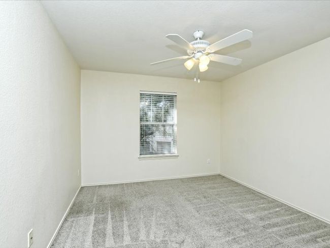 Carpeted empty room featuring baseboards and a ceiling fan | Image 19