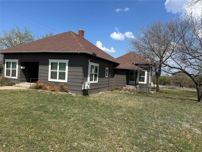 View of front of home with a chimney, a front lawn, and roof with shingles | Image 5